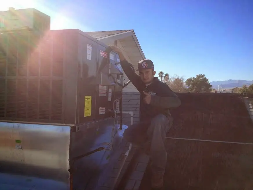 HVAC technician performing HVAC Inspection on a rooftop unit in Burke